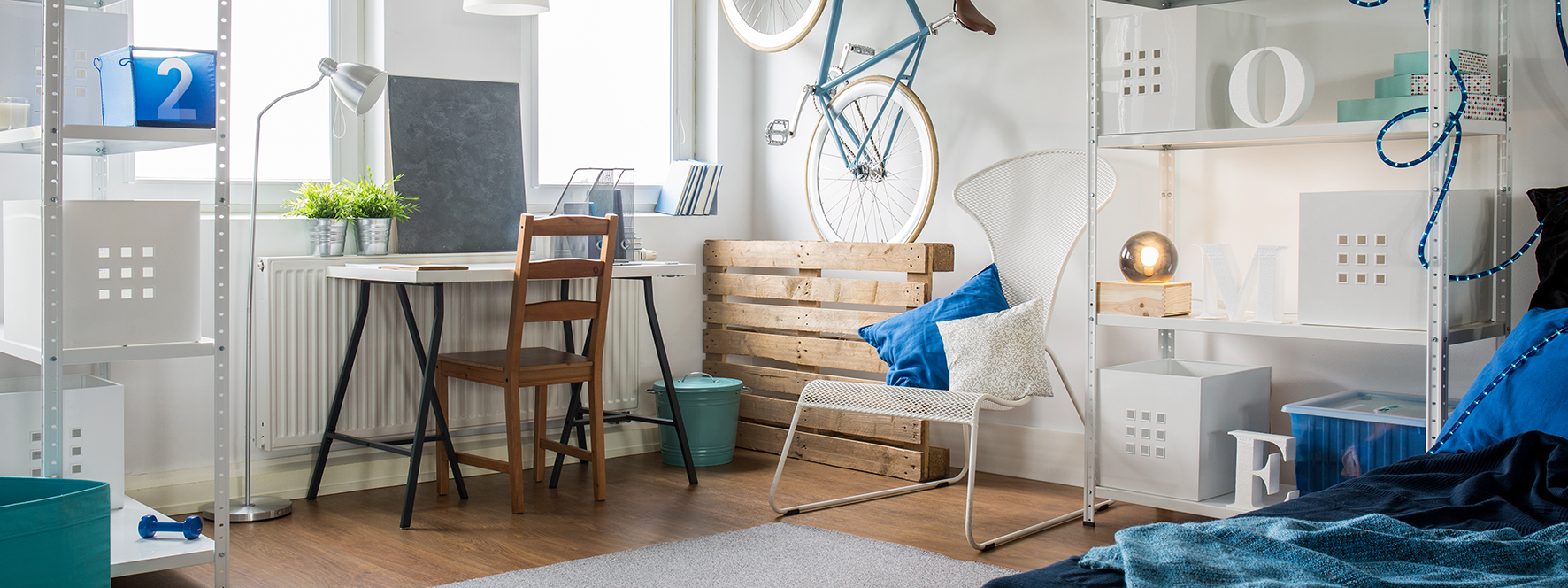 Ett rum med en massa möbler och saker i. På väggen hänger en cykel.