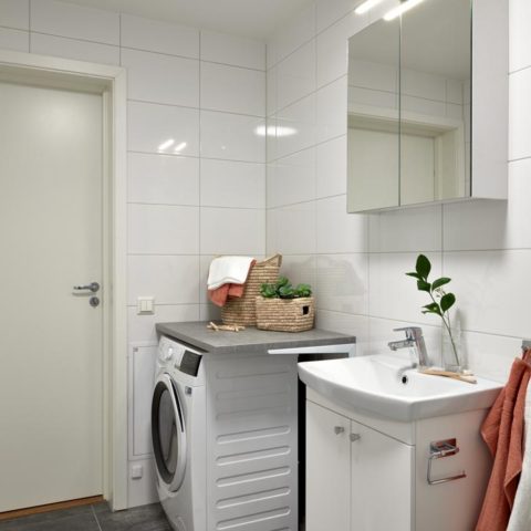 Ett badrum med tvättmaskin