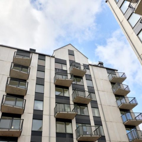 Ett vitt bostadshus med balkonger