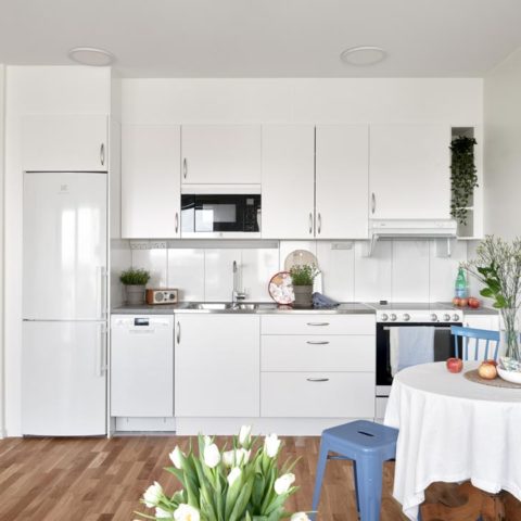 Ett vitt kök där man ser en tulpanbukett på bordet