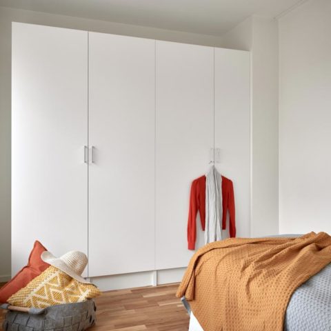 Ett sovrum där man ser garderober