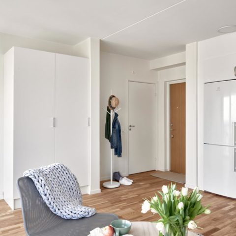 Ett vardagsrum där man ser en grå fåtölj