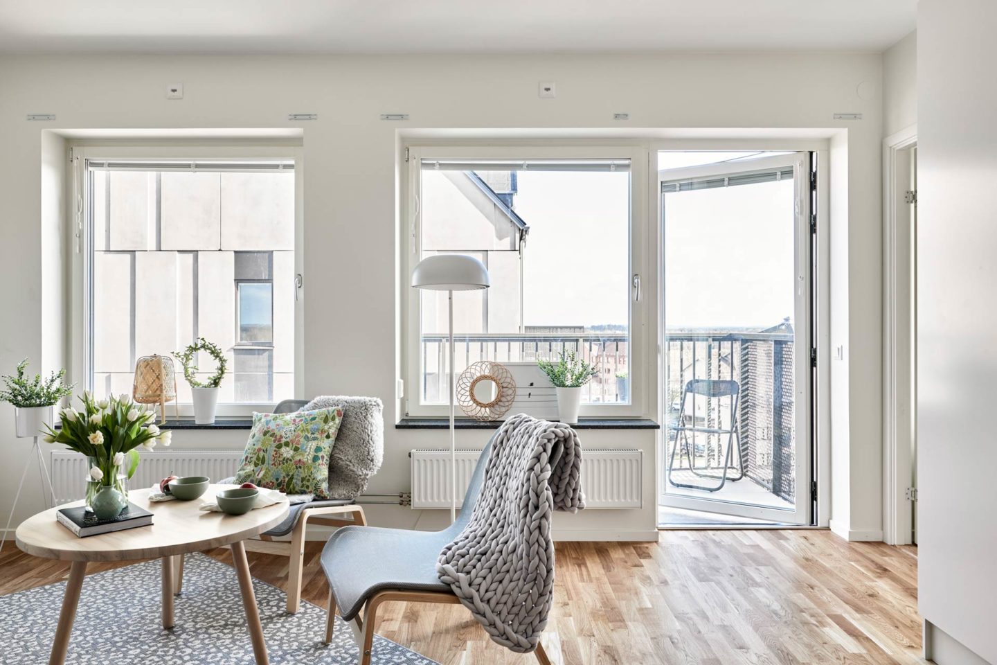 Ett ljust vardagsrum där man ser ett soffbord i trä och två stolar