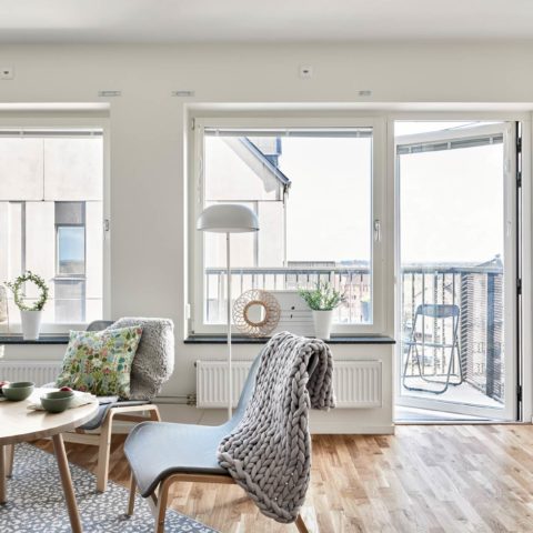 Ett ljust vardagsrum där man ser ett soffbord i trä och två stolar