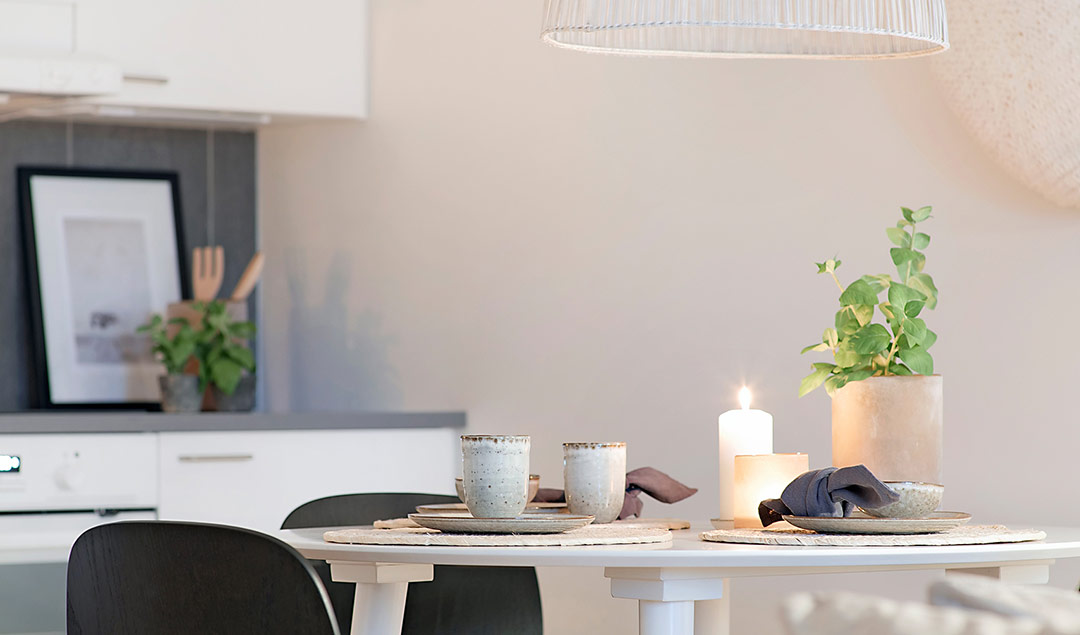 En närbild på ett köksbord där ett blockljus är tänt