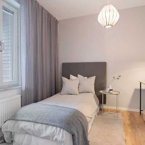 Ett gästrum med en liten gästsäng i hörnet