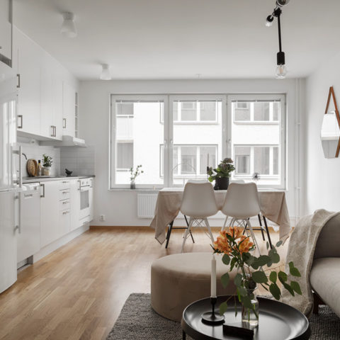 Ett ljust kök och vardagsrum med stora fönster