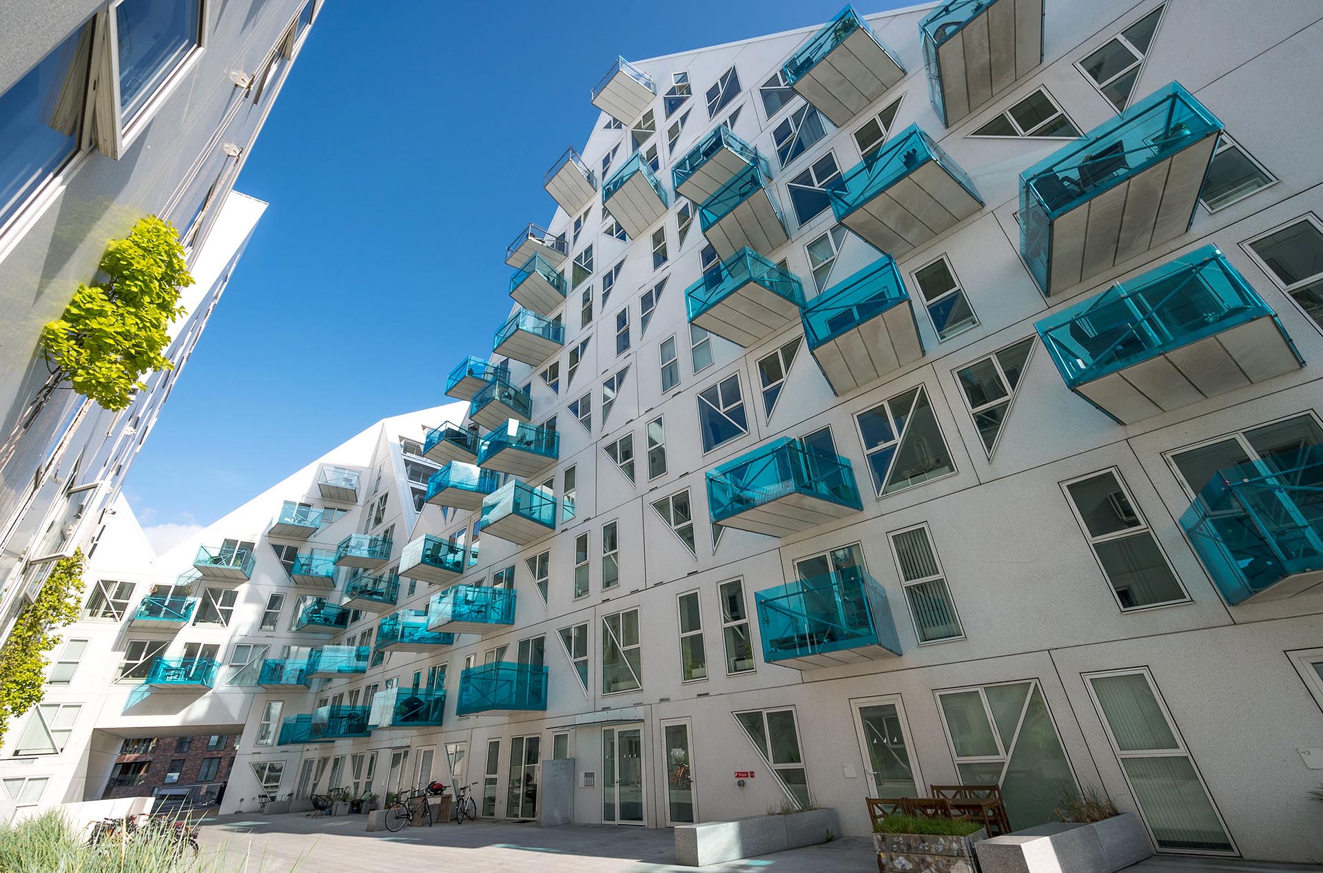 Ett stort vitt bostadshus med blåa balkonger