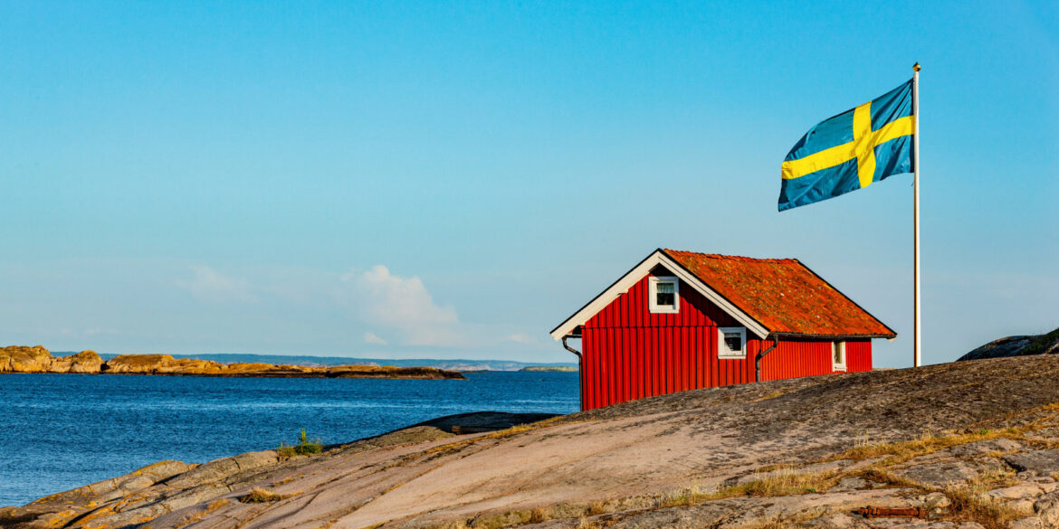 En röd stuga vid vattnet som man kan njuta av under sin hemester.
