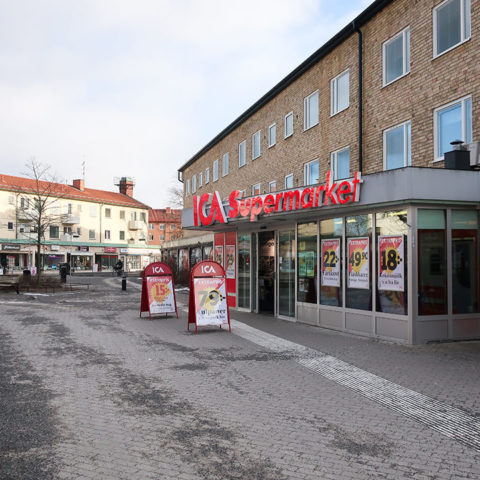 Ett 60-tals hus i gult tegel med Ica supermarket i botten av huset