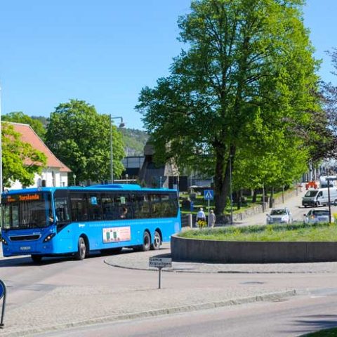 En blå buss som kör på en väg