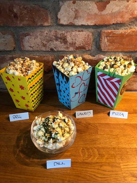 Fyra olika popcornbägare med olika smaker.