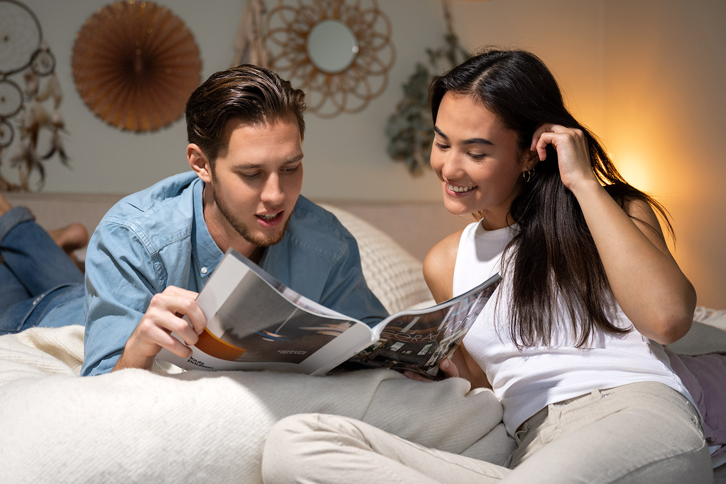 En man och kvinna ligger i sängen och läser en tidning