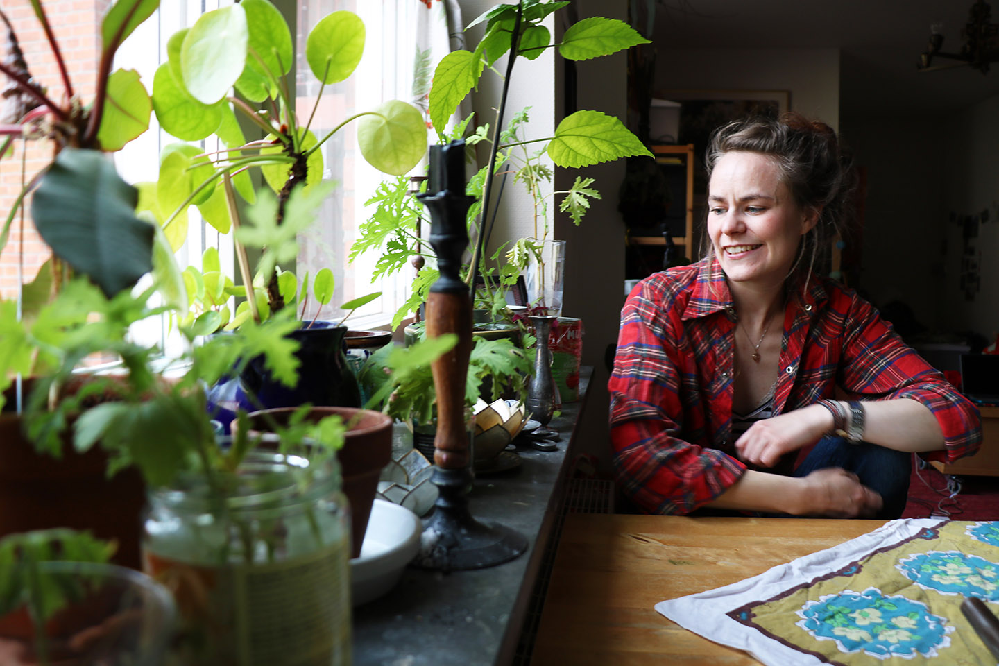 En tjej med rutig skjorta sitter vid sitt köksbord