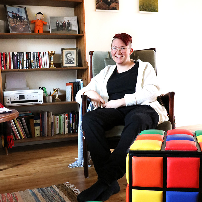 En tjej sitter i en fåtölj i ett rum