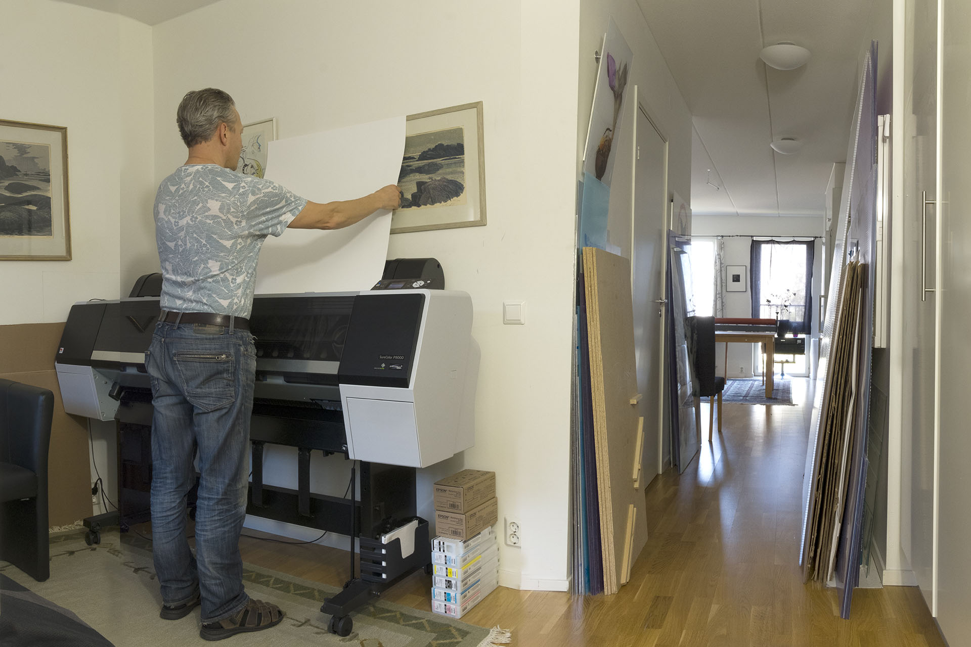 En man står vid sin laminator i sin lägenhet