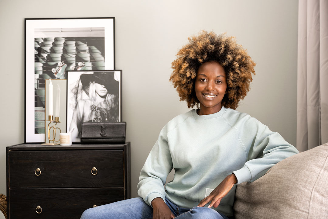 heimstaden_kvinna_leende_interiör_tavlor_förvaring_greige