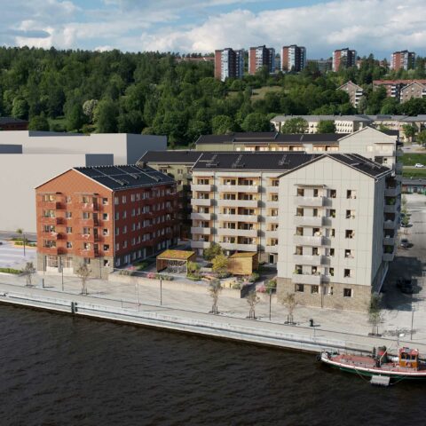 En vy över några bostadshus som ligger precis vid vattnet