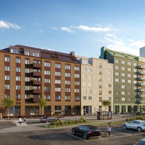 Ett brunt, ett vitt och ett grönt bostadshus som sitter ihop