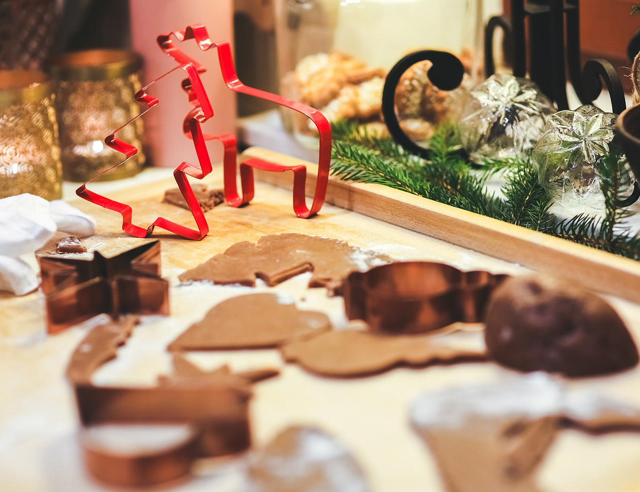 En köksbänk i trä som det ligger utstansade pepparkakor och formar på.