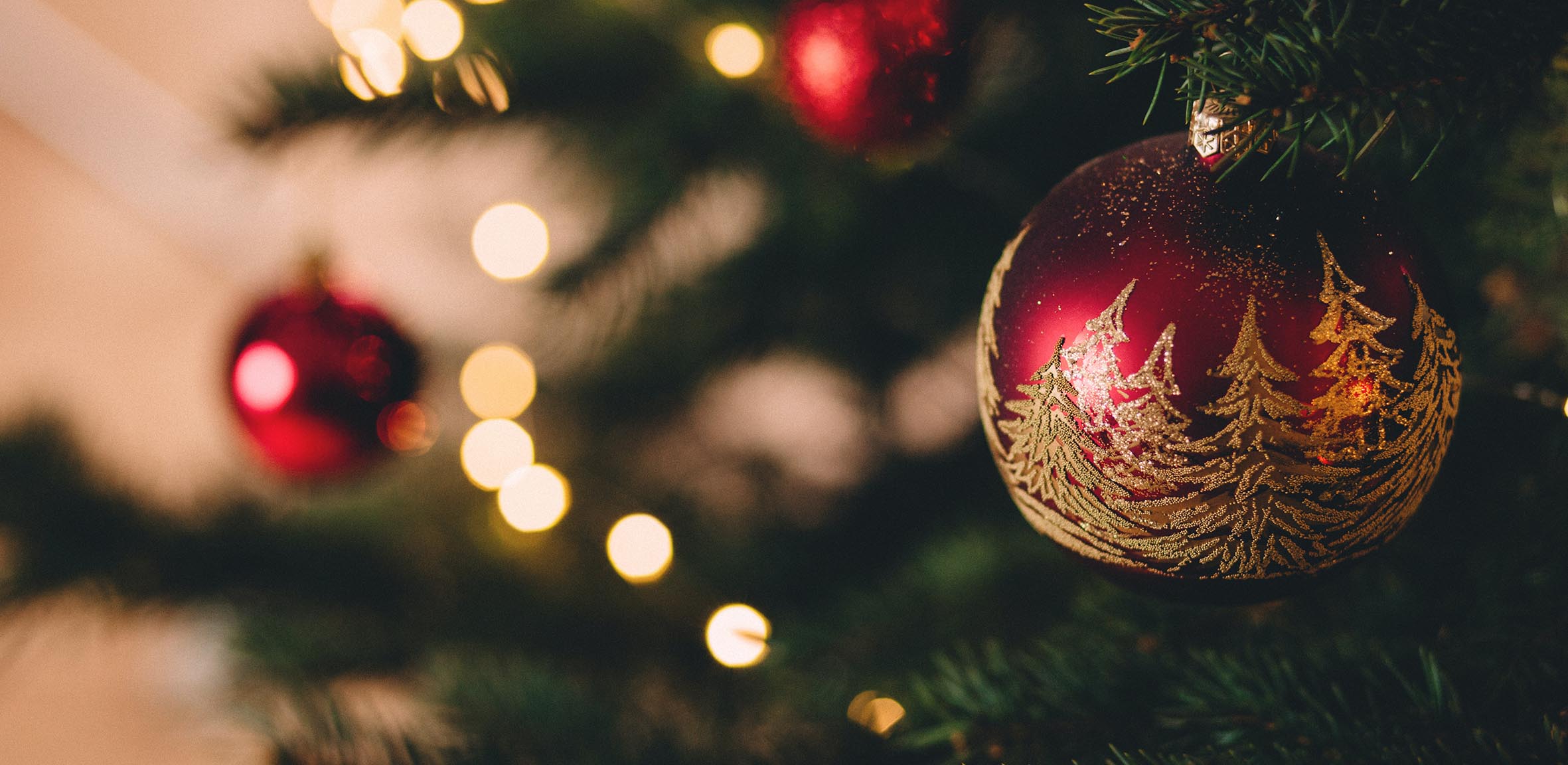 En röd julgranskula med gulddetaljer