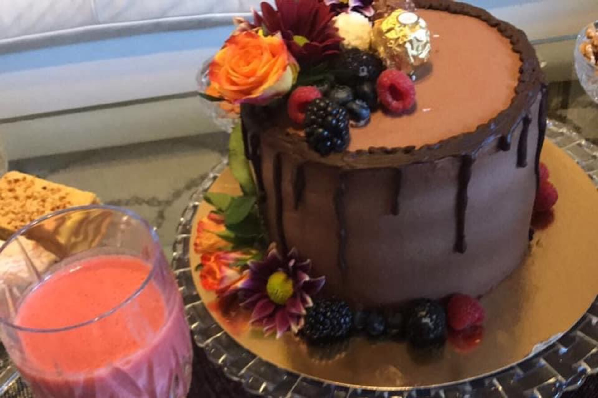 en stor chokladtårta och ett glas med en rosa smet