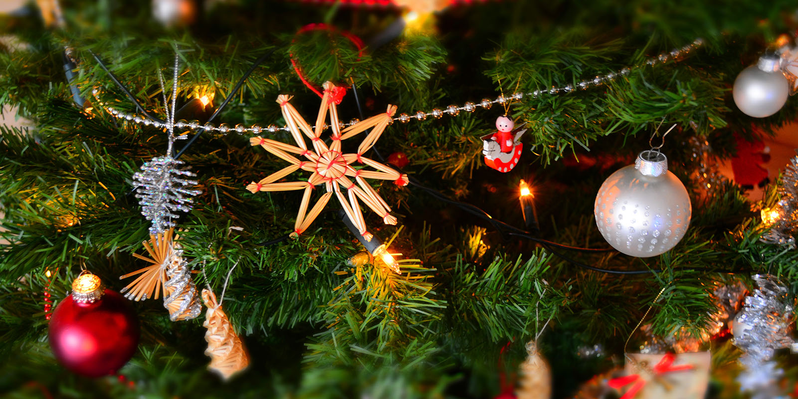 En närbild på en julgran där det hänger massa julpynt