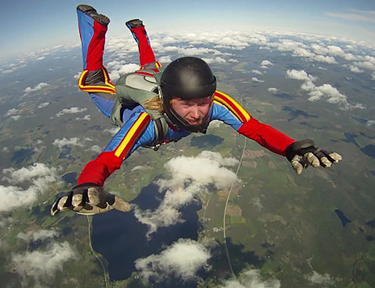 En kille med blå och röd dräkt hoppar fallskärm