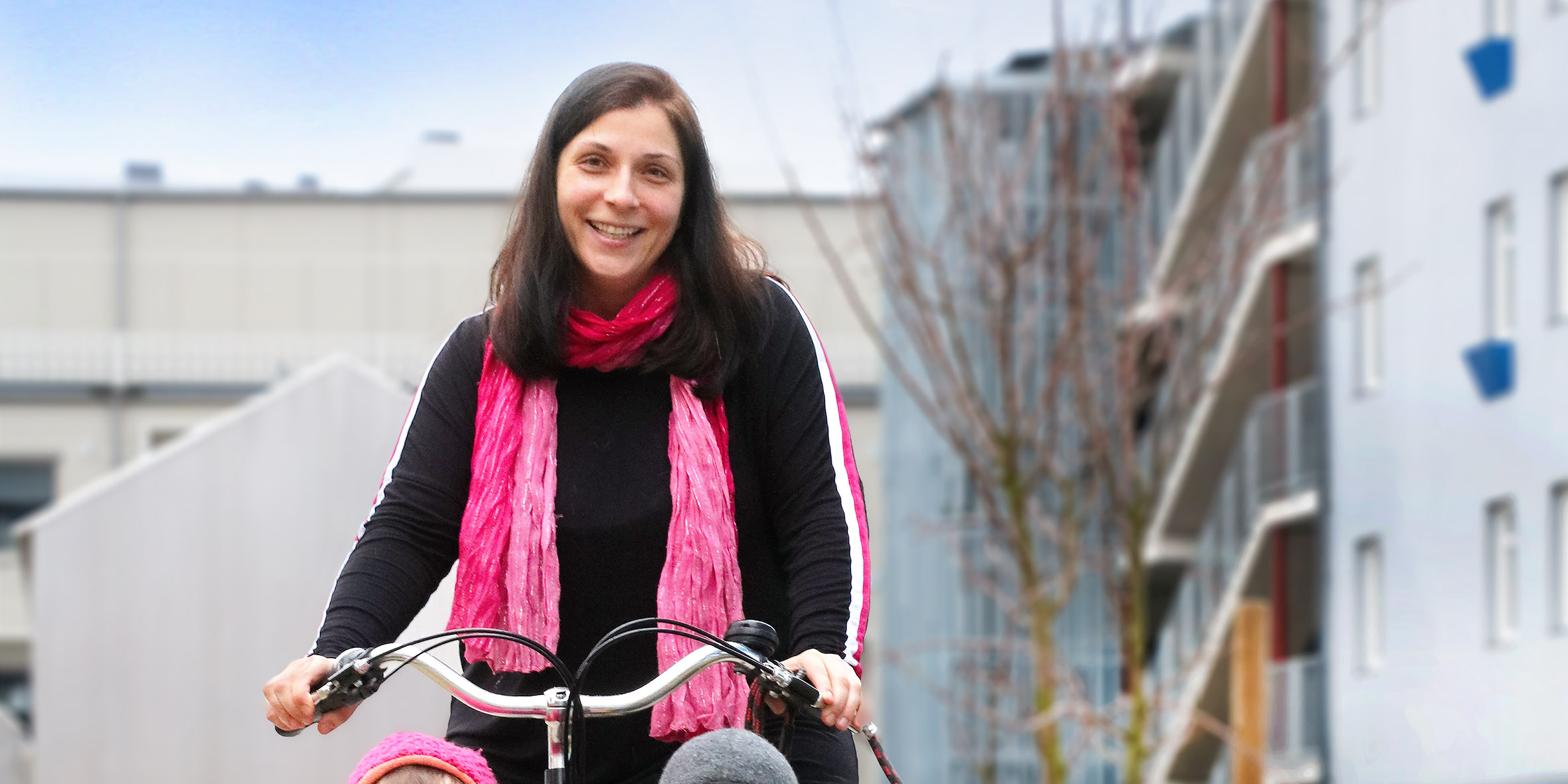 En kvinna med en rosa halsduk cyklar