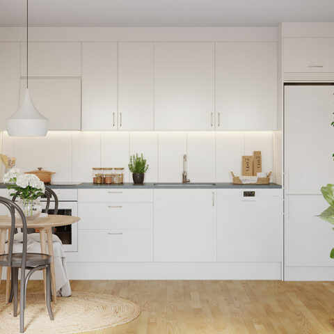 Vitt kök i öppen planlösning med matplats och vardagsrum