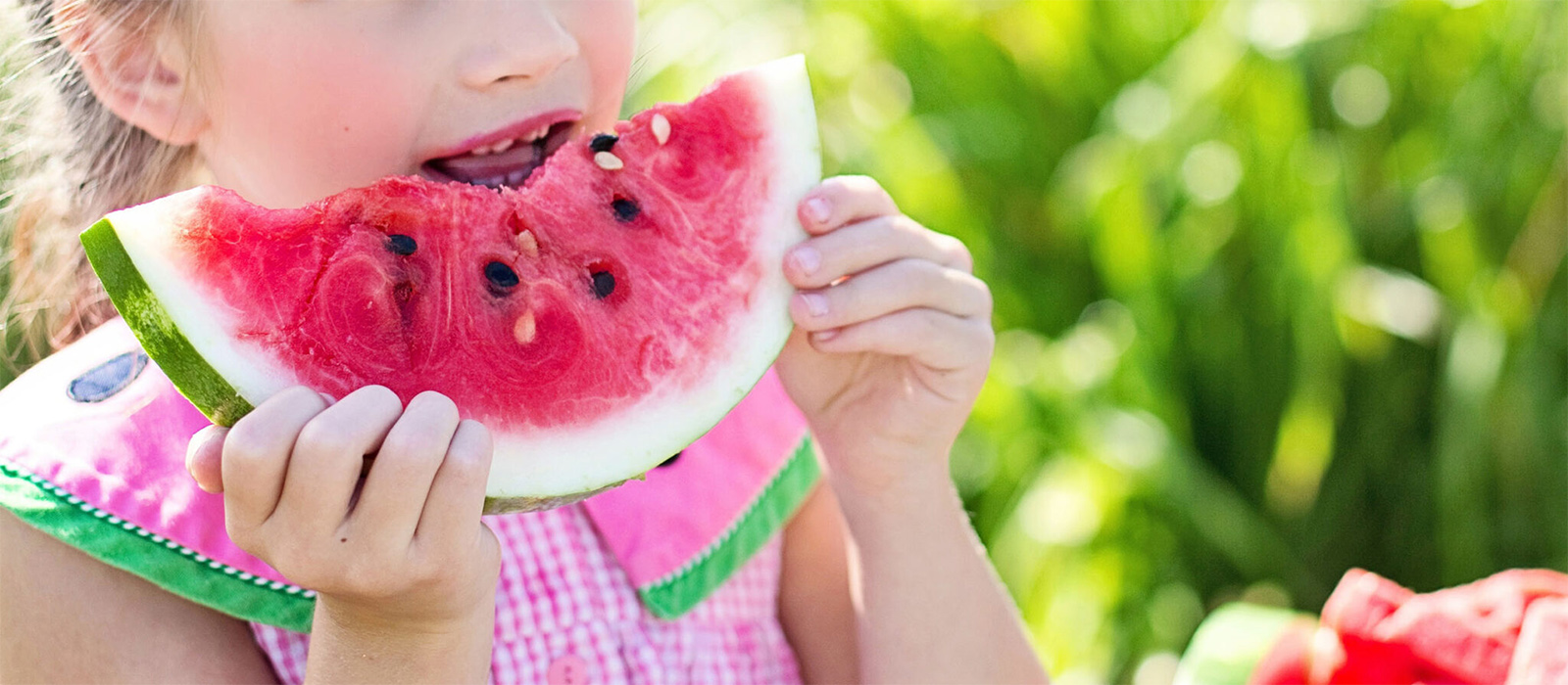 En närbild på en flicka som äter en vattenmelon.