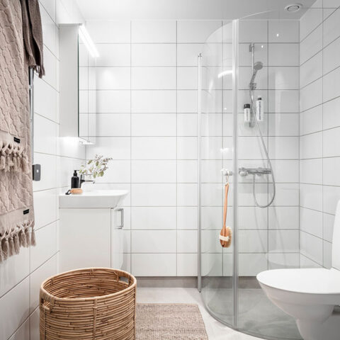 Inrett badrum med dusch och tvättmaskin.