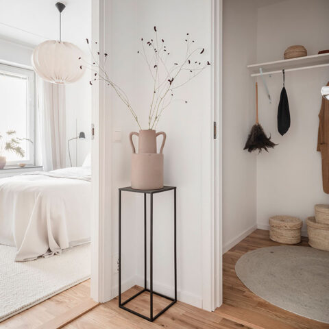 Inredd hall i vackert ljus med ingång till sovrum och en walk in closet.