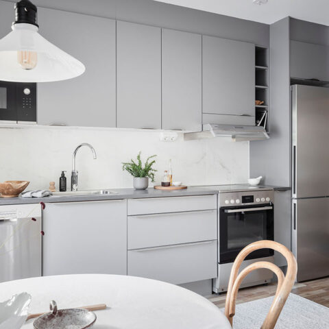 Ett inrett kök med grå köksluckor.
