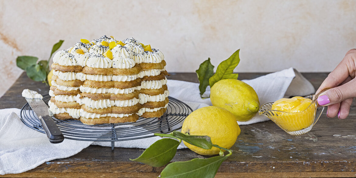 En våffeltårta som ligger på ett fat med några citroner som ligger bredvid som dekoration.