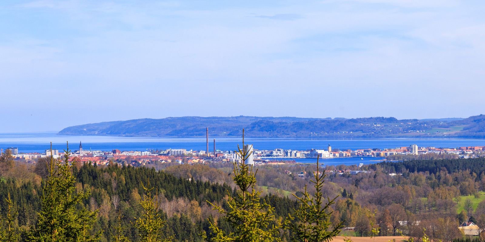 En vy över staden Jönköping där man ser Vättern, berget Taberg och sen en massa byggnader och industrier.