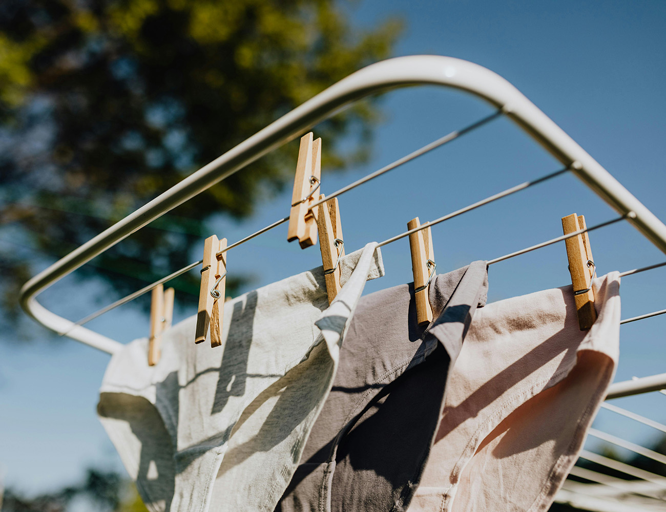 En klädställning som det det hänger underkläder på med bruna trä klädnypor.