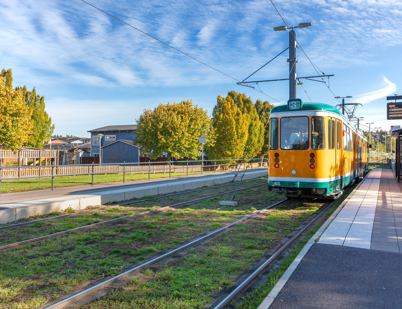 En gul spårvagn i Norrköping i ett bostadsområde där Heimstaden har lägenheter.