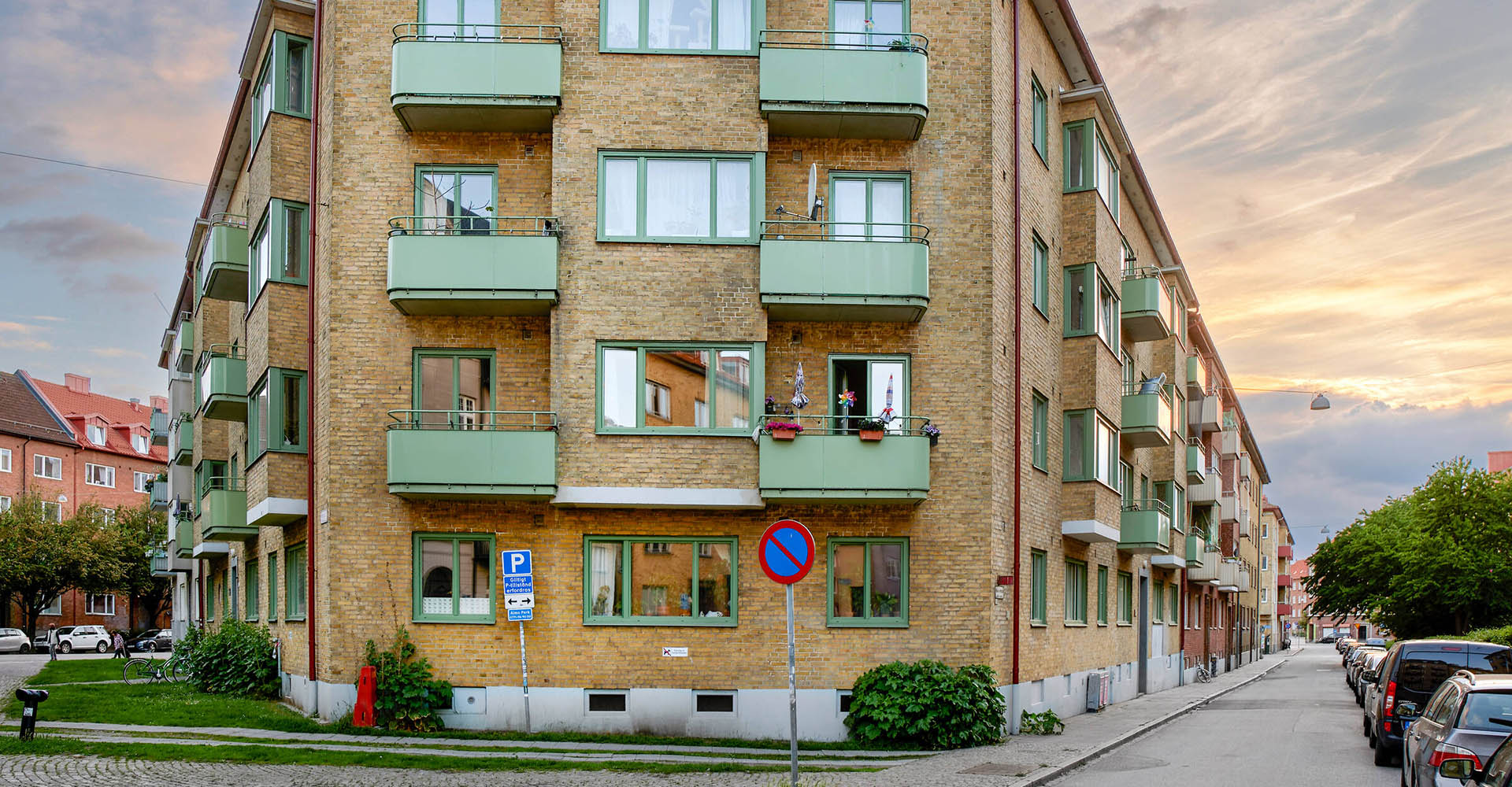 En gul tegelbyggnad med gröna balkonger i stadsdelen Norra Sofielund i Malmö.