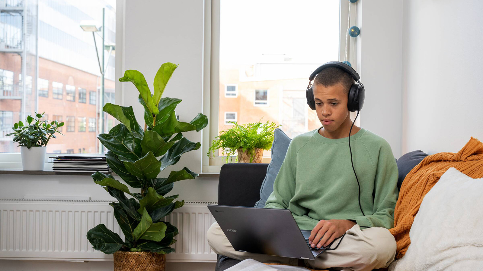 En student sitter i sin studentlägenhet och pluggar.