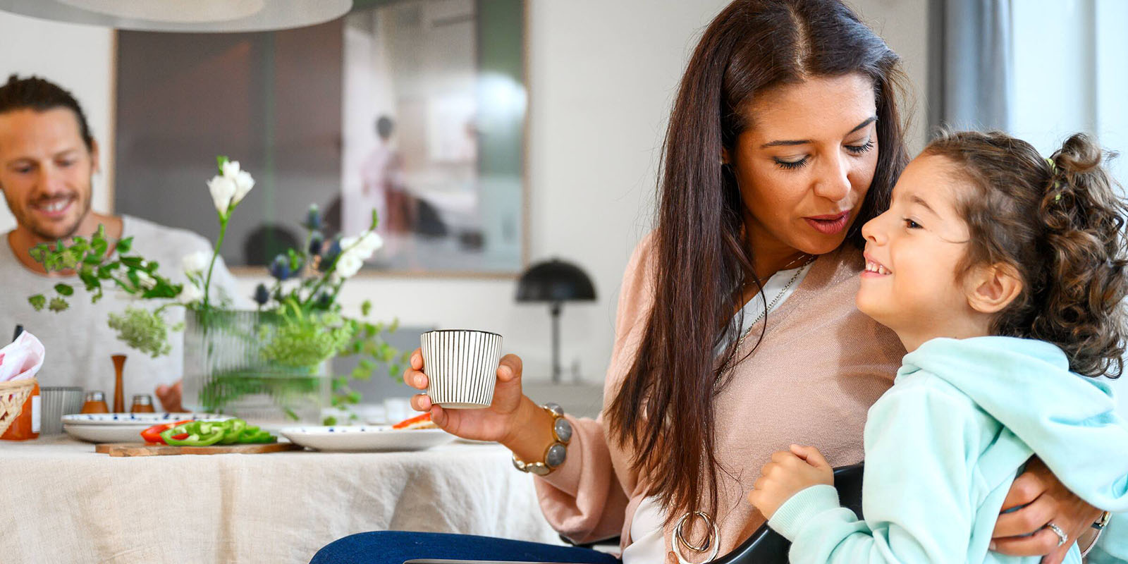 En mamma och dotter sitter vid ett köksbord i en Heimstaden lägenhet.