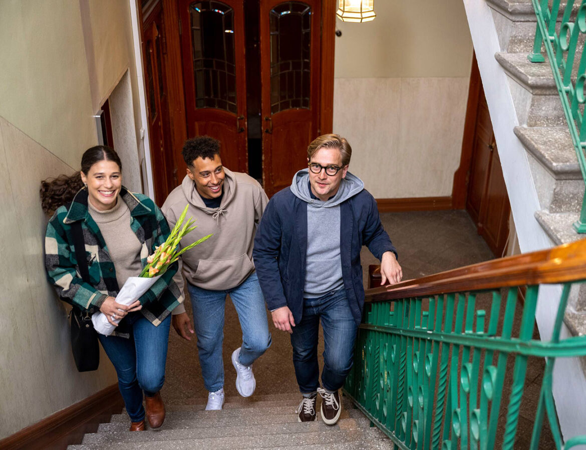 Tre ungdomar på väg upp för en trappa, symboliserande studenter som utforskar och trivs i sina studentbostäder i Växjö.