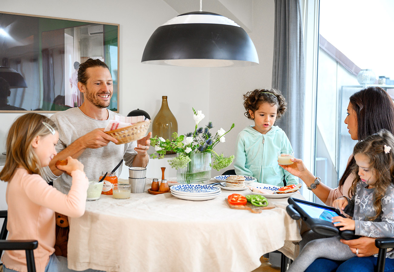 En familj sitter runt ett köksbord och äter frukost i en lägenhet i Falköping.