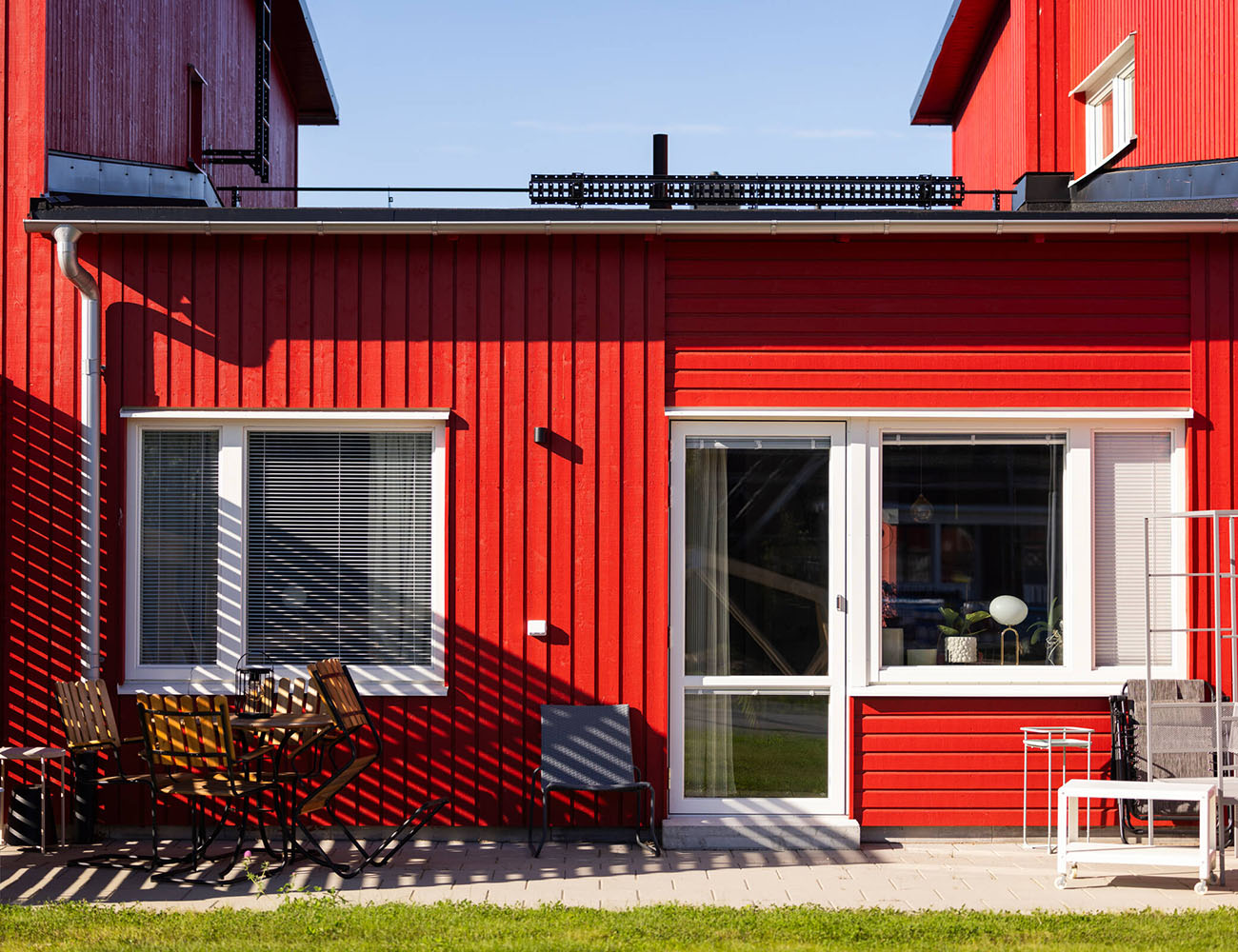 En röd träbyggnad med en uteplats i området Vårsådden i Skellefteå där vi har erbjudande just nu på lägenheter.