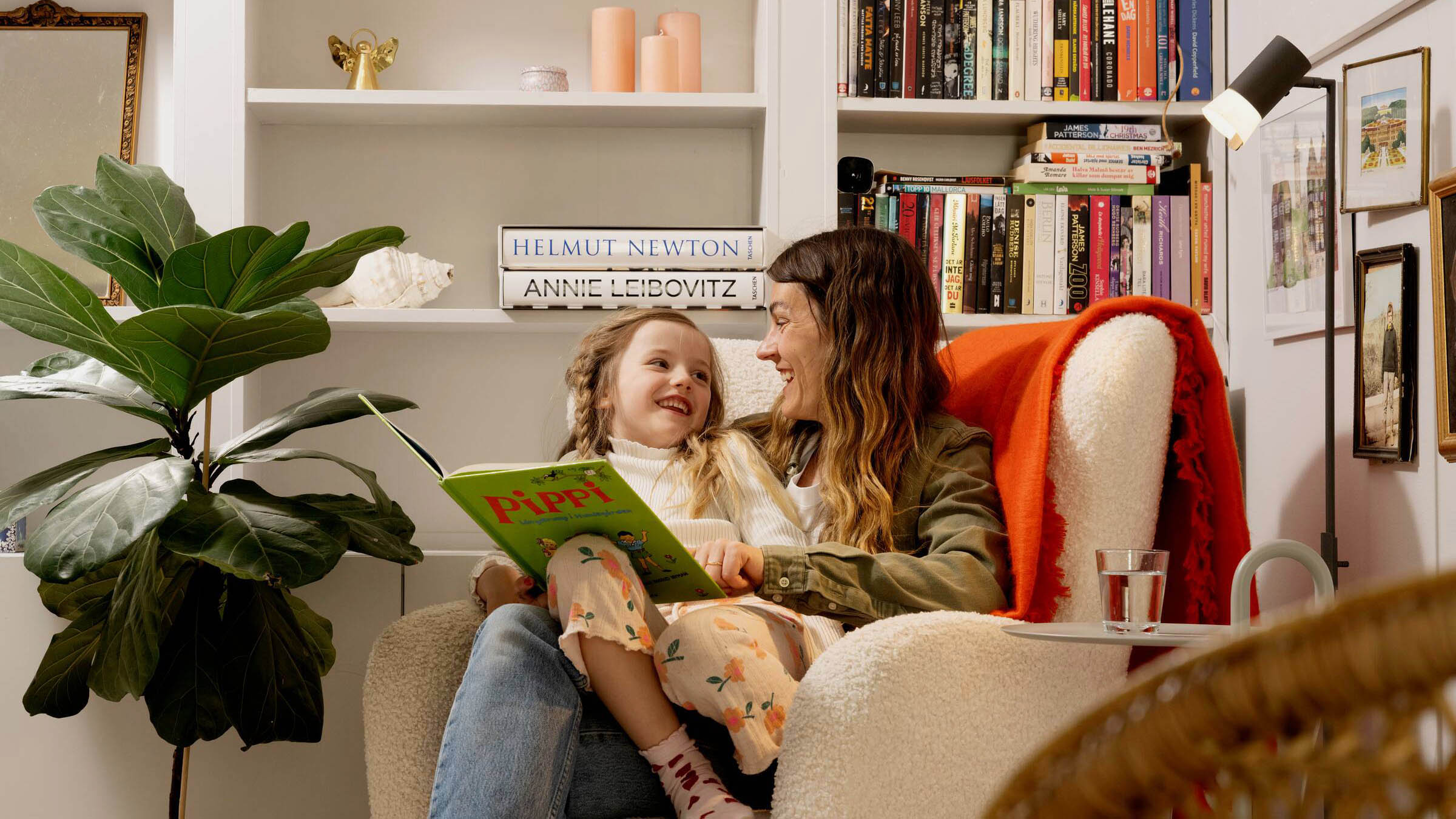 Mamma och dotter sitter i en fåtölj i en Heimstaden lägenhet.