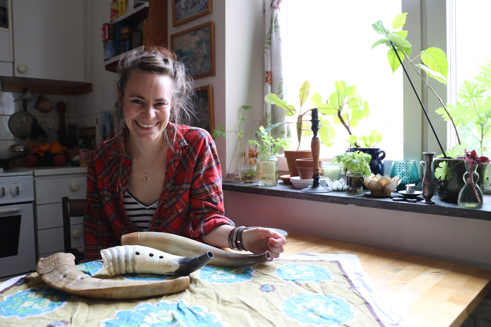 En mörkhårig tjej sitter vid sitt köksbord