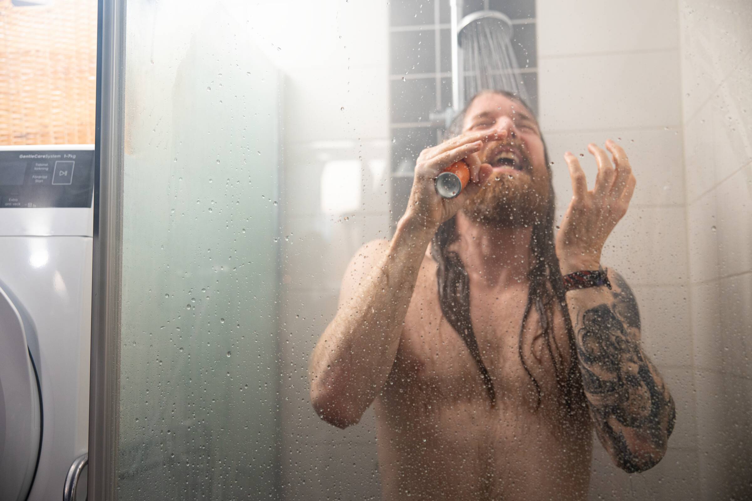 man zingt in douche