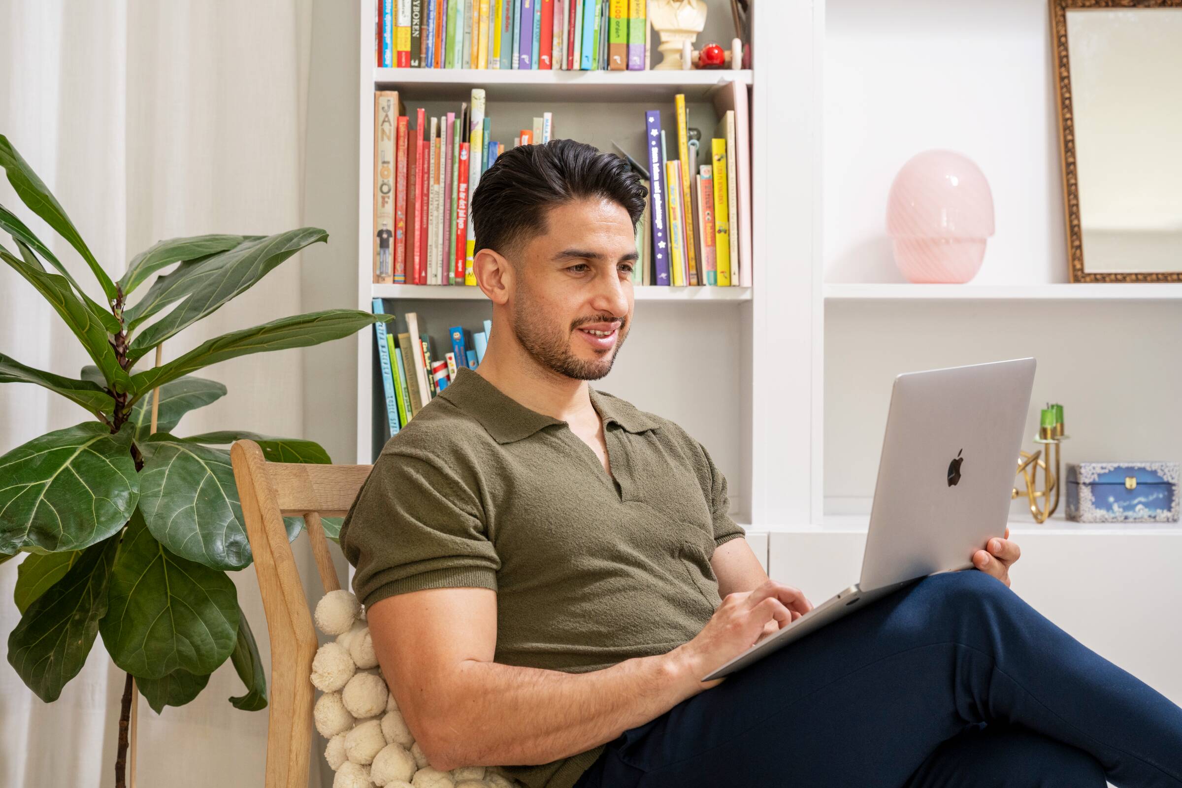 Mann sitter og ser på en datamaskin