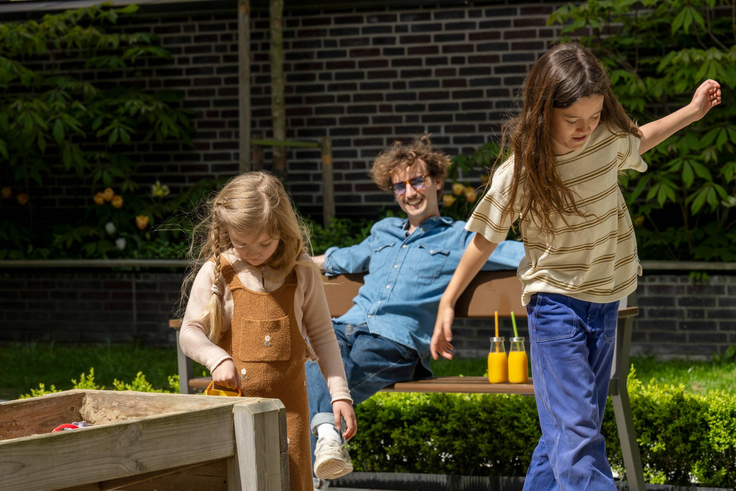 Ojciec z dziećmi na placu zabaw