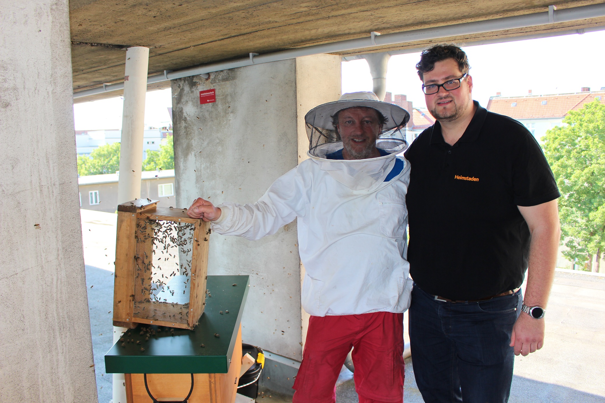 Imker und Heimstaden Mitarbeiter Stadtbienen e.V. auf dem Dach von Mietwohnung